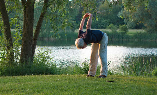 Wellness: It’s Not Just for the Privileged Few a woman stretching outside in a park