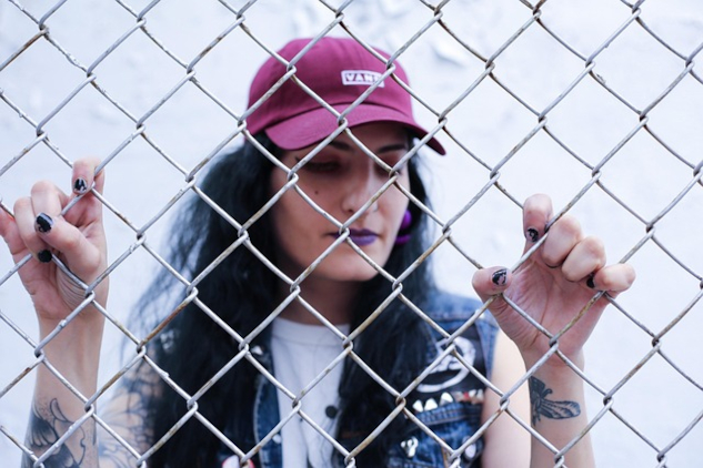 A woman standing behind a chain link fence.&nbsp;Image by Daryl Bambic from Pixabay.&nbsp;